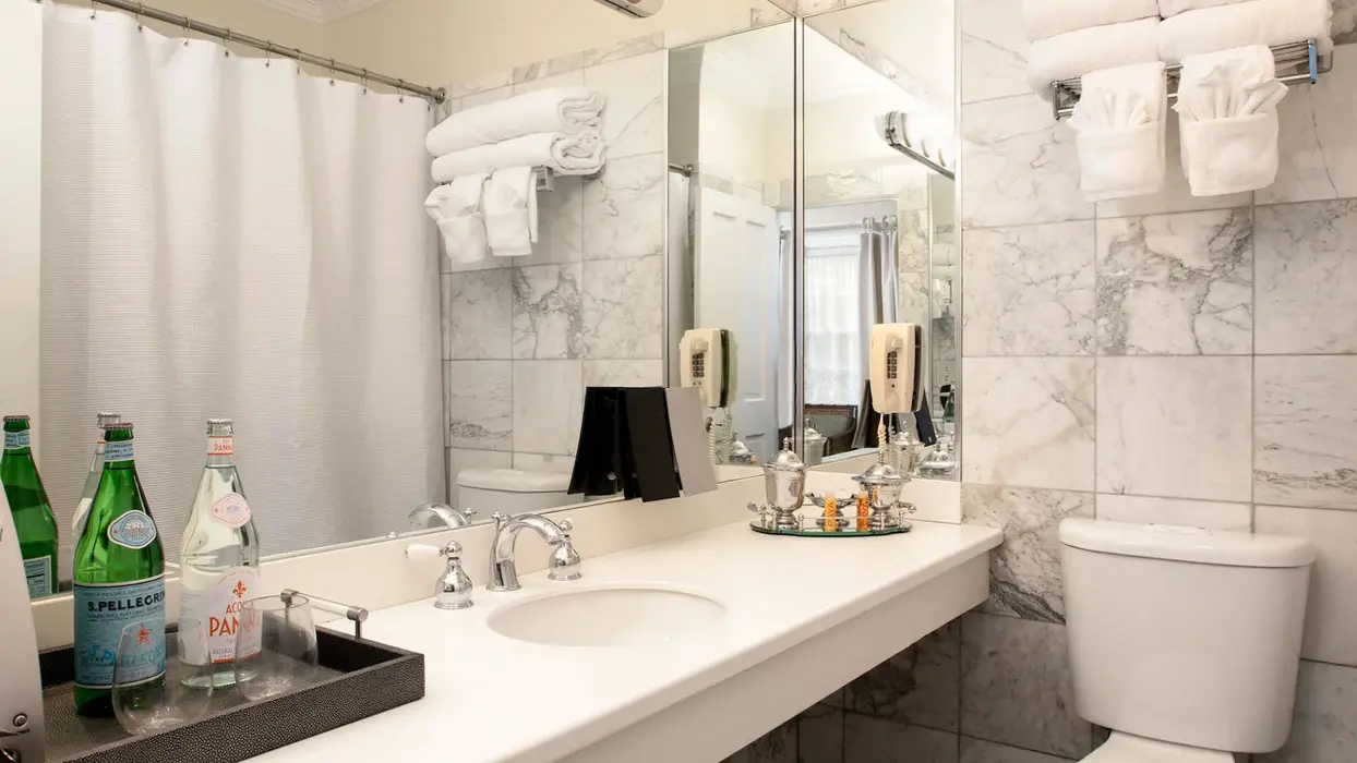 Modern marble guest room bathroom with white vanity and towels
