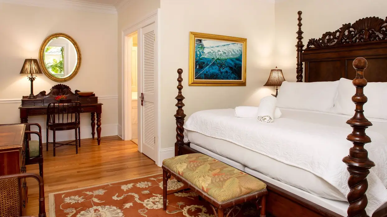 Four-poster bed and writing desk in a classic guest room.