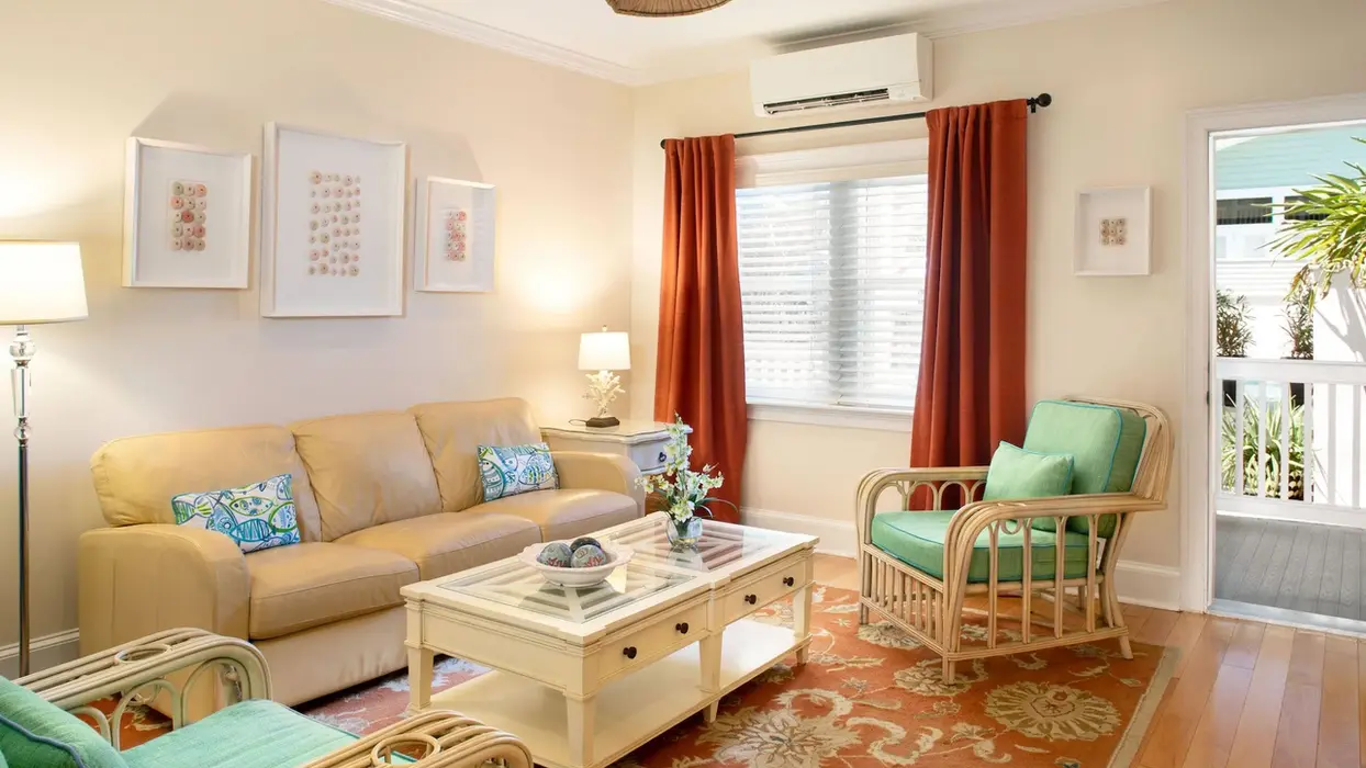 Cozy cottage living room with wicker chairs and sofa.