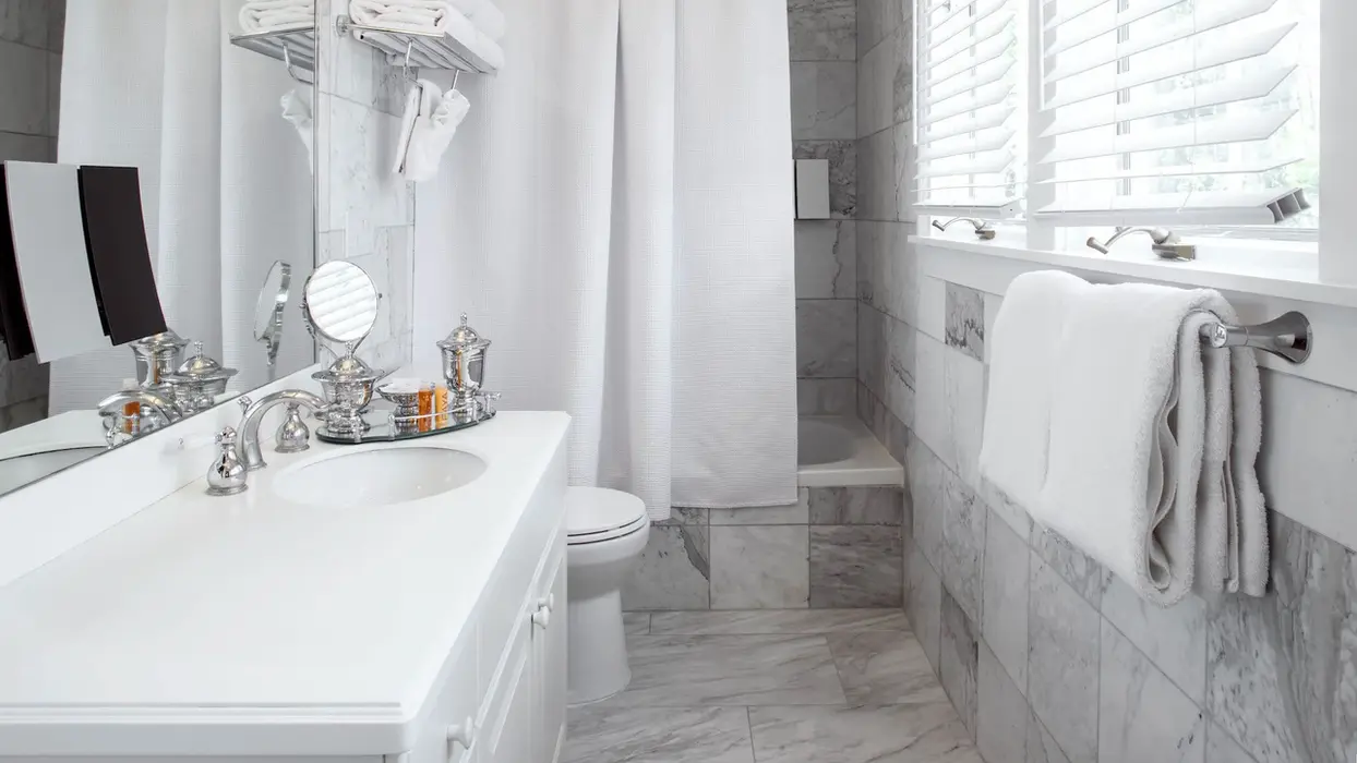 Modern white guest room bathroom with marble tiles.