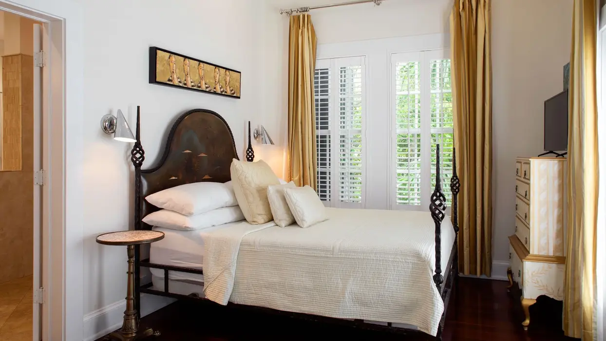 Elegant cottage bedroom with a black four-poster bed.