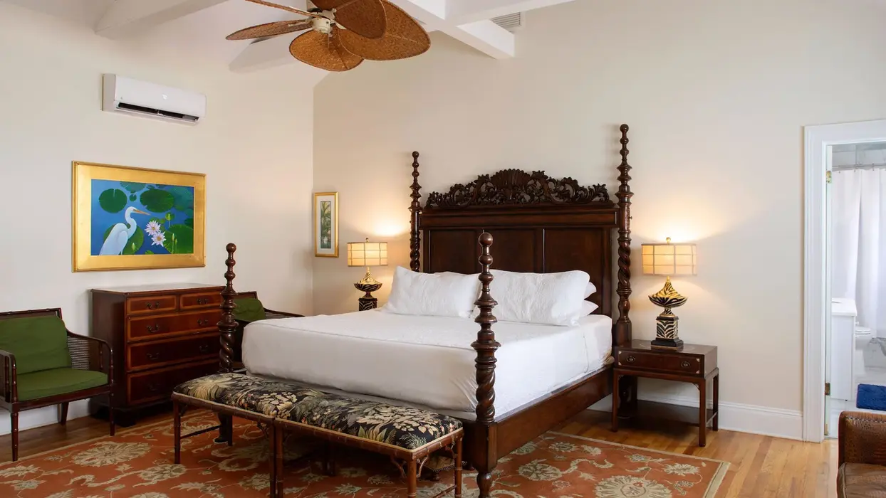 Guest room with a mahogany four-poster bed and ceiling fan.