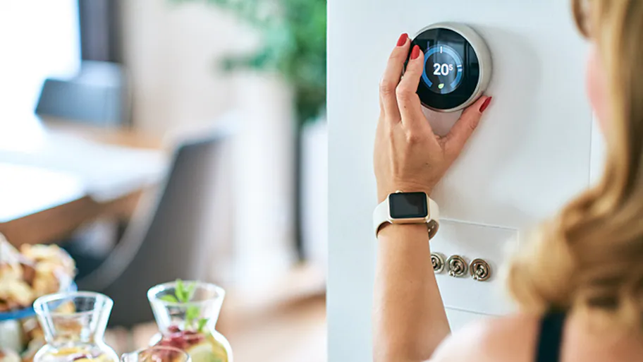 woman adjusting AC thermostat