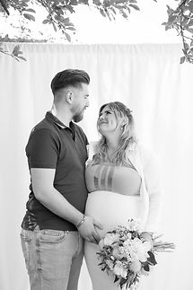 Lorena mit Babybauch und Kevin während sie sich anlächeln 