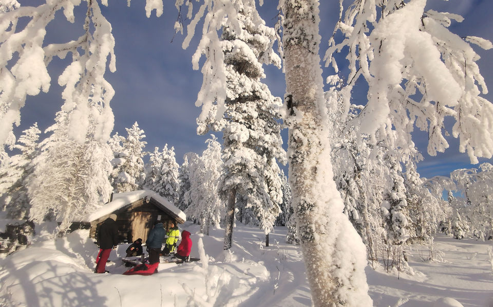 People spending time in small cottage surrounded by snow