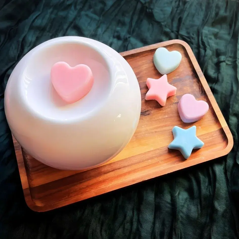 a white ceramic wax warmer with star and heart shaped winter wax melts