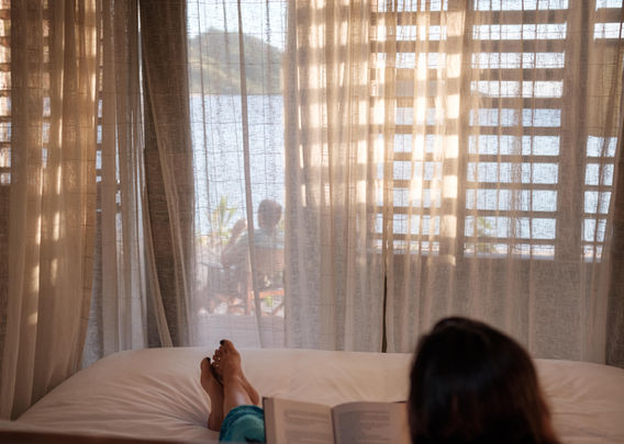 Sea views from bed inside a Beachfront Bure at Barefoot Kuata Island Resort_