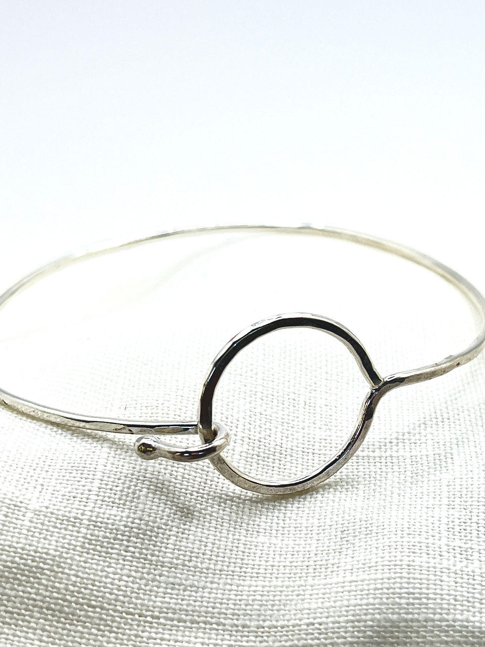 silver bangle bracelet with circle geometric clasp on white background