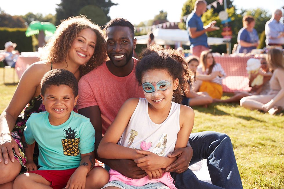 a smiling family sits together outdoors