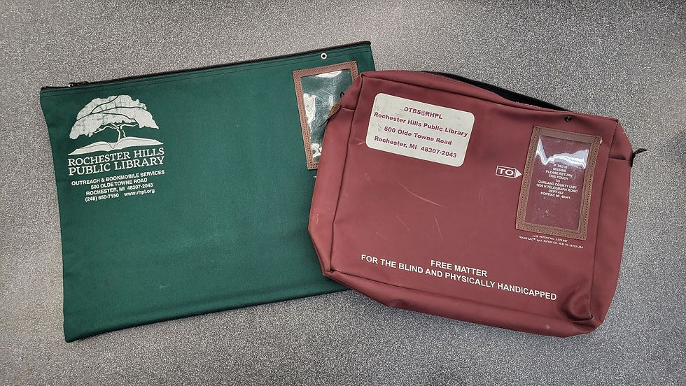 The Books by Mail zipper pouches, a larger green bad with the RHPL camperdown elm tree logo and address in the corner and a smaller, burgundy bag with "Free matter for the blind and physically handicapped" and the OTBS/RHPL return address on the front.