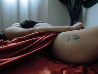 tattoo on a woman's thigh with orange fabric on her
