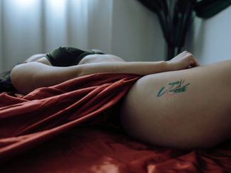 tattoo on a woman's thigh with orange fabric on her