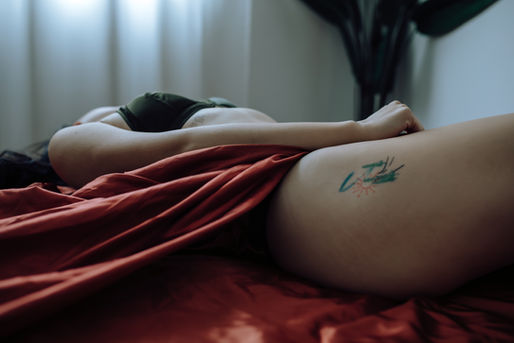 tattoo on a woman's thigh with orange fabric on her