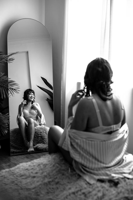 Woman wearing lingerie and smiling in mirror