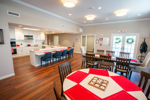 Dining room at Evergreen Gardens Assisted Living in Strongsville, Ohio, a senior care home with bright decor, wooden floors, and tables set for communal meals, fostering connection and comfort in senior care home living.