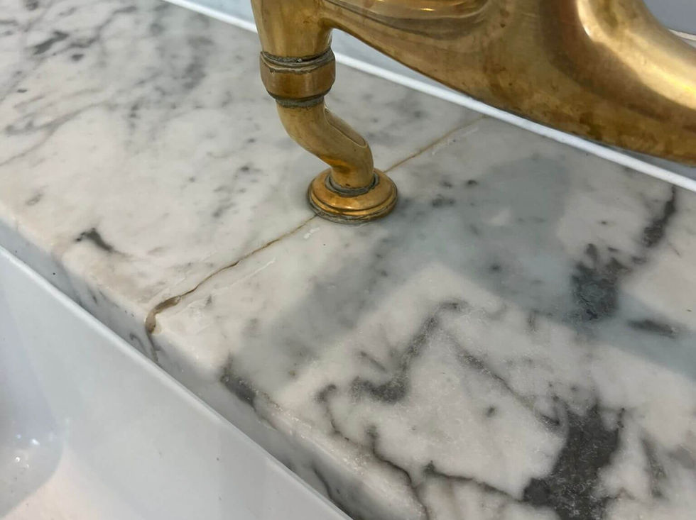 damaged marble worktop crack behind brass tap close view