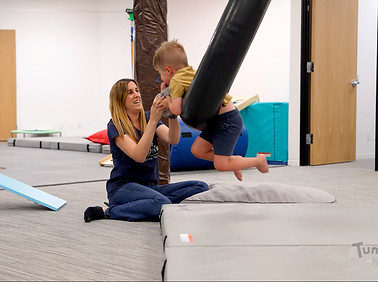 Occupational therapist with boy in therapy gym, Los Angeles business promotion by PolkaPop! Productions.
