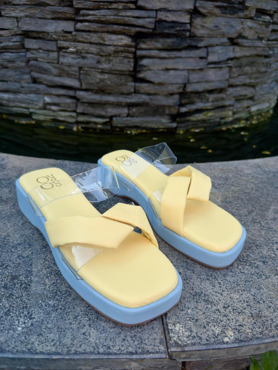 Pair of yellow sandals on display with TWO TONE PLATFORM - Yellow near water.