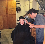 Kori the barber is giving a haircut.