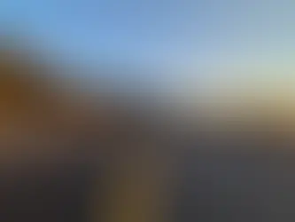 Two-lane mountain pass road at dawn with a clear path forward and wide sky space for a headline.