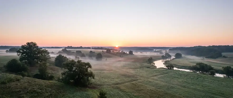 Fog lifting over a valley at sunrise with open sky space, setting a calm hero banner about getting legal help.