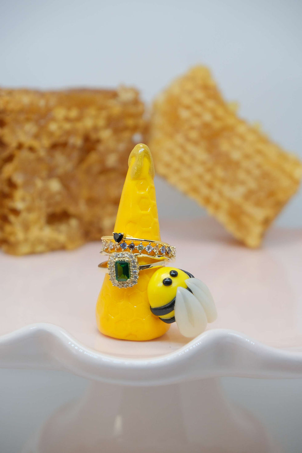 Thumbnail: Yellow ring holder with dripping honey and a cute chubby bee, that can be used to display multiple rings.