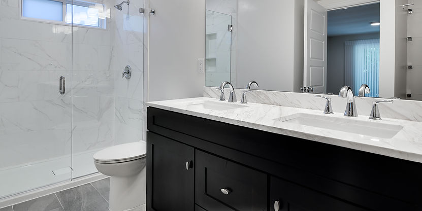Bathroom remodel by Tortoise Construction in Lake Oswego featuring a dark wood double vanity, marble countertop, and modern tub-shower combo.