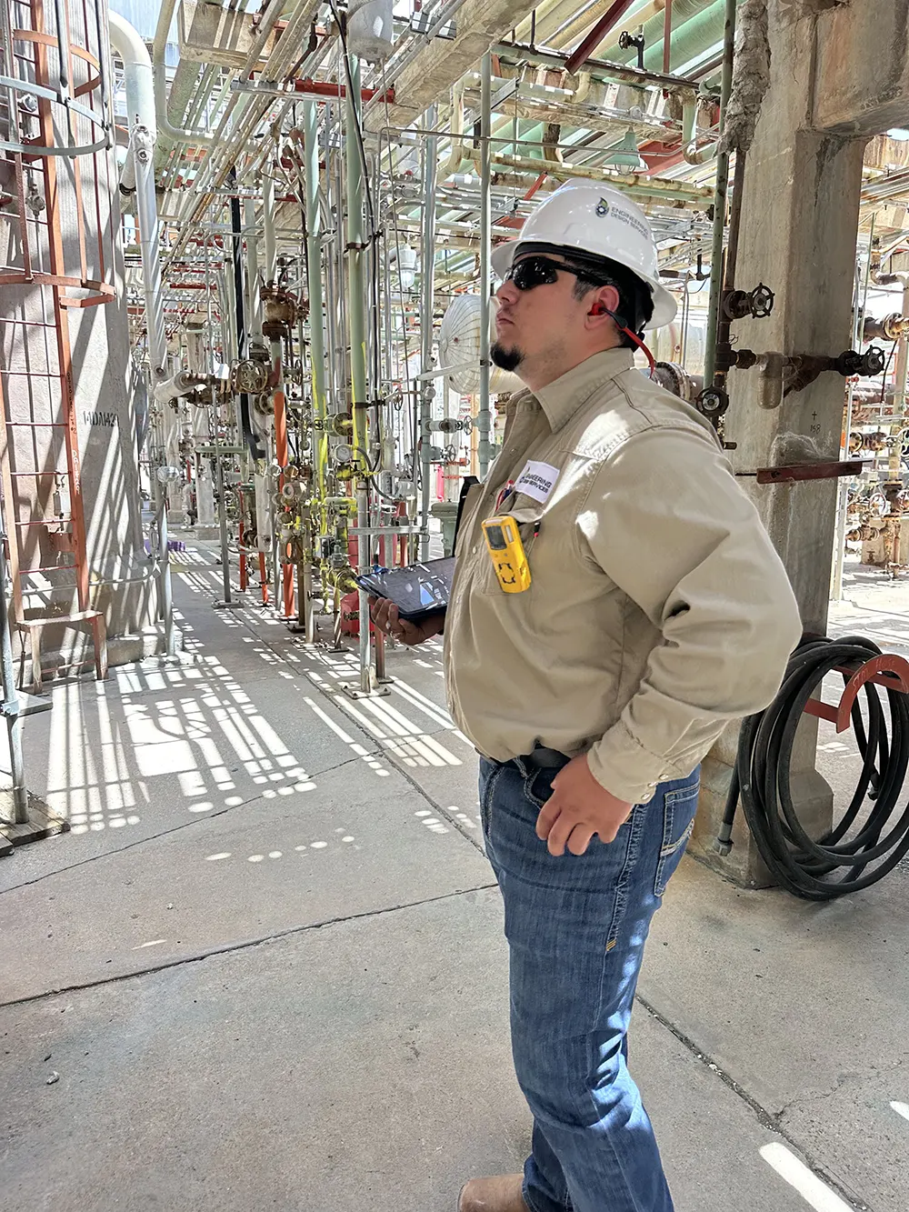 Engineer looking at a piece of equipment in a refinery