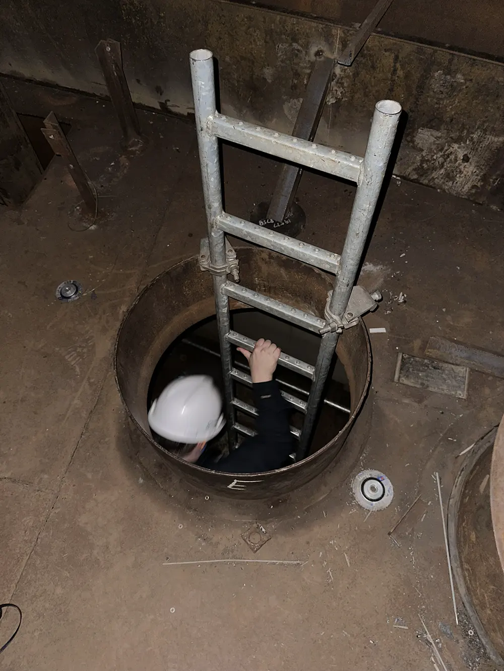 Engineer climbing a ladder in a tank