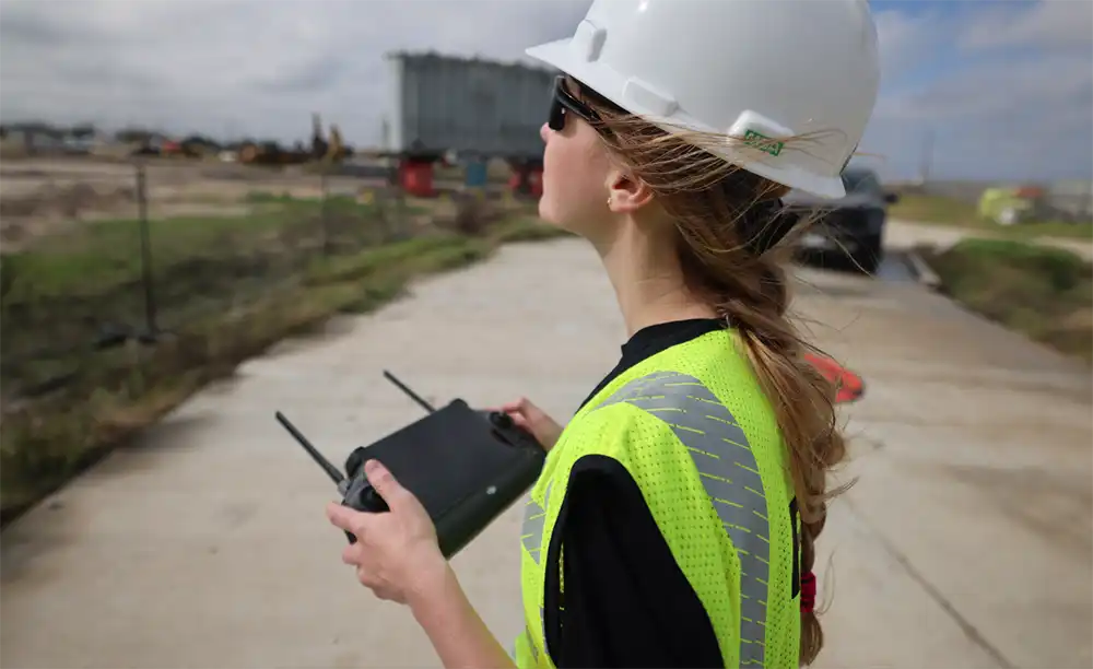Engineer using drone controller on a construction site for monitoring