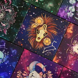 Canvases featuring colourful illustrations of various animal skulls and flowers on starry backgrounds, inspired by astrological signs.
