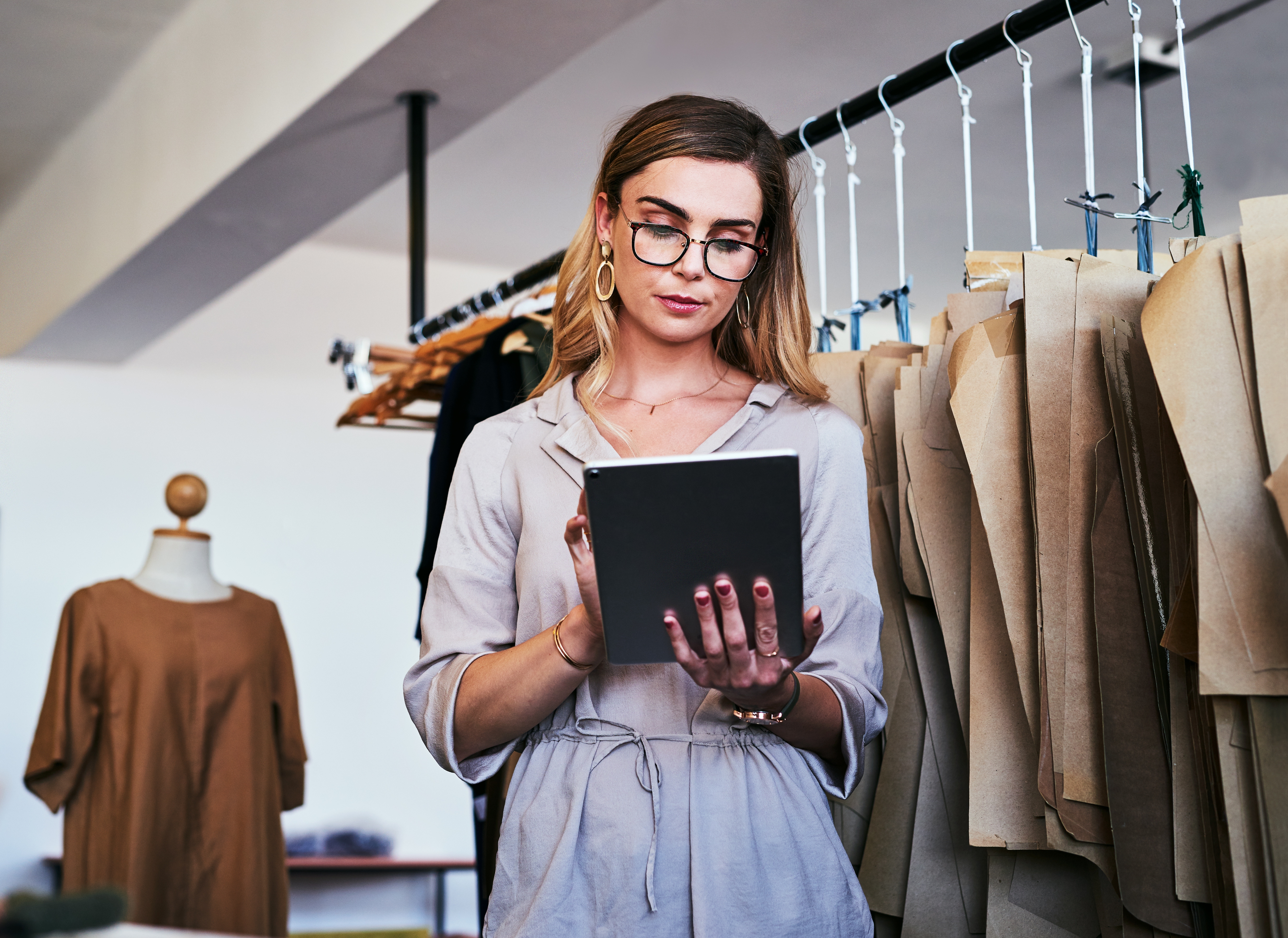 Fashion designer, small business; woman on tablet managing e-commerce store.