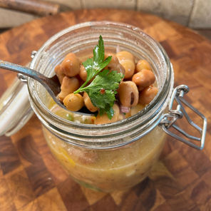 A jar of marinated fava beans with fresh parsley