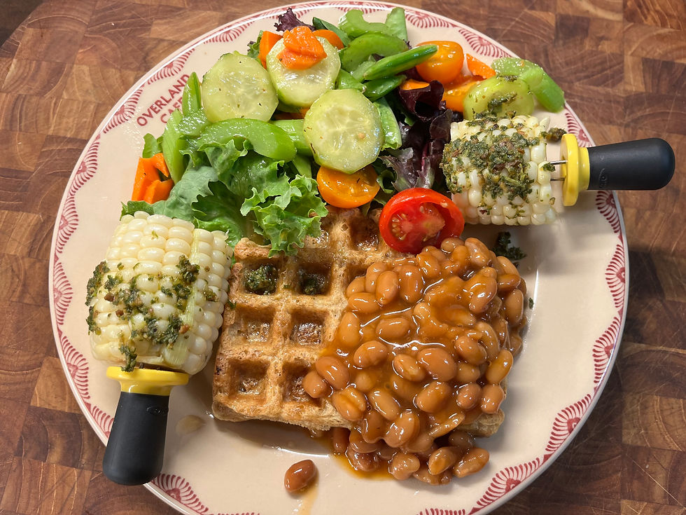 plate with waffles, beans, salad and corn on the cob