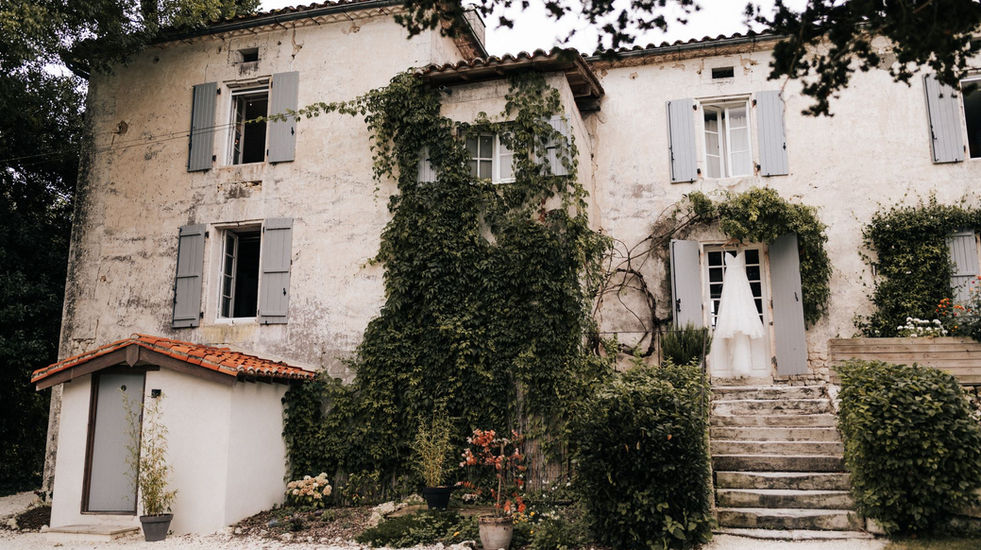 Wedding dress hanging in the doorway - Stylish Manor House wedding venue in the Charente