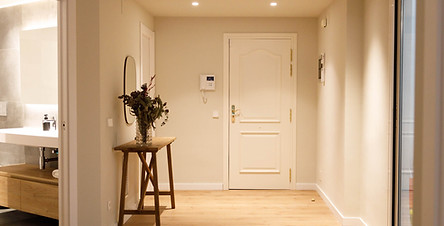 Clean, modern hallway with front door and open bathroom