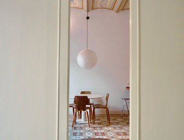 Ornate ceiling, patterned floor, and round ottoman in an elegant room.