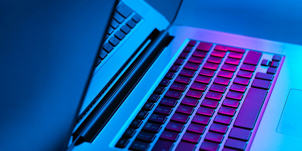 Laptop with a partially open lid glows in blue and pink light, highlighting the keyboard. The mood is tech-focused and modern.