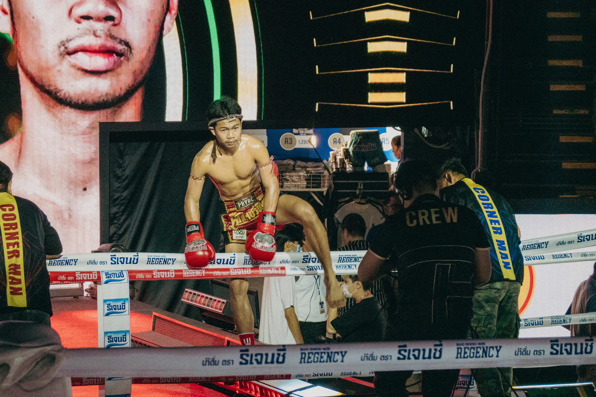 Muay Thai Fighter climbing over the ropes into the ring