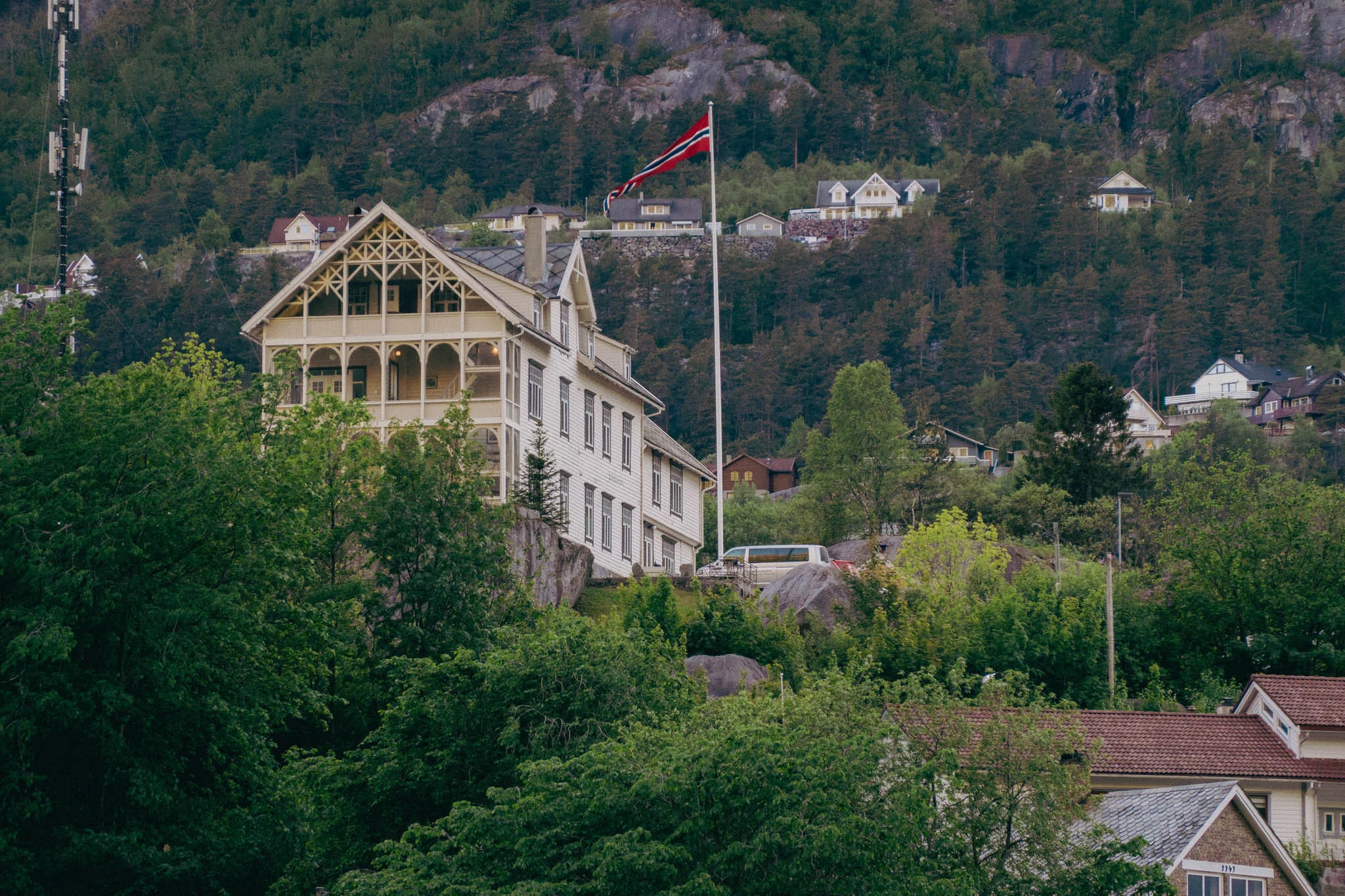 Hotel building in the mountainside with a Norwegian flag flying above it