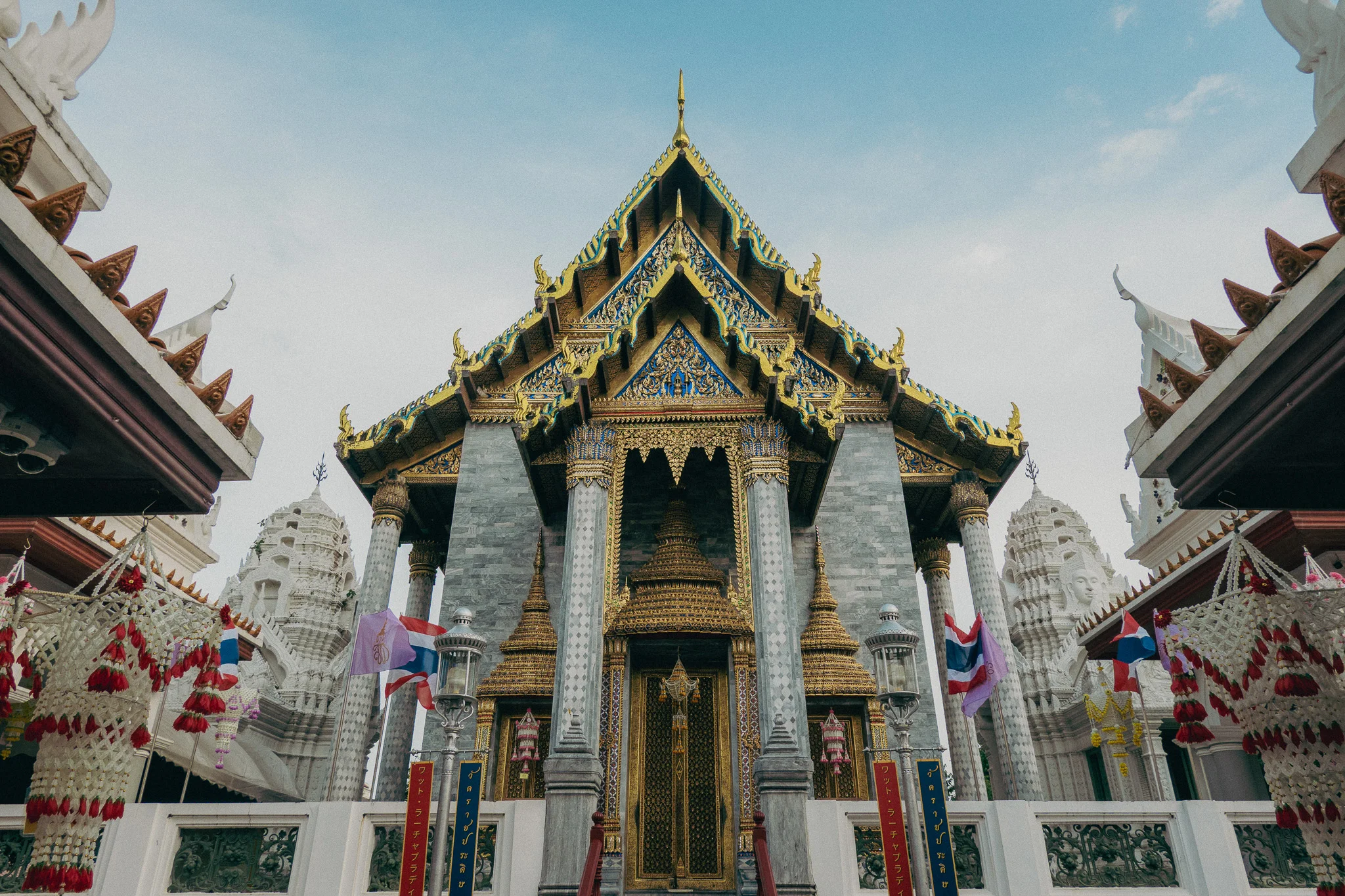 Large Thai temple with gold roofing and white pillars