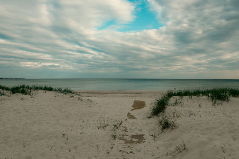 wide shot view of the ocean and swirling clouds in the sky at Höllviken beach in Sweden