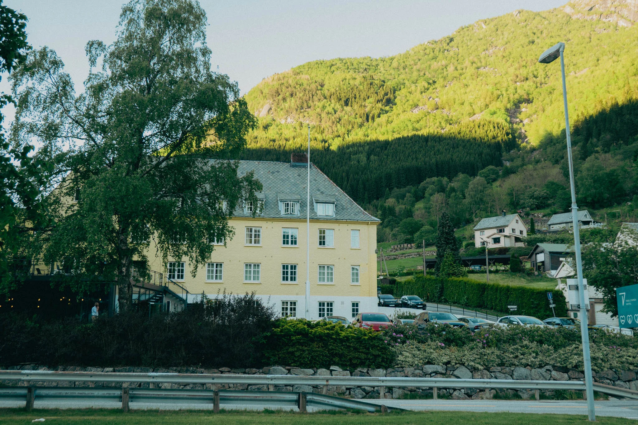 Trolltunga hotel in front of green sunlit mountains