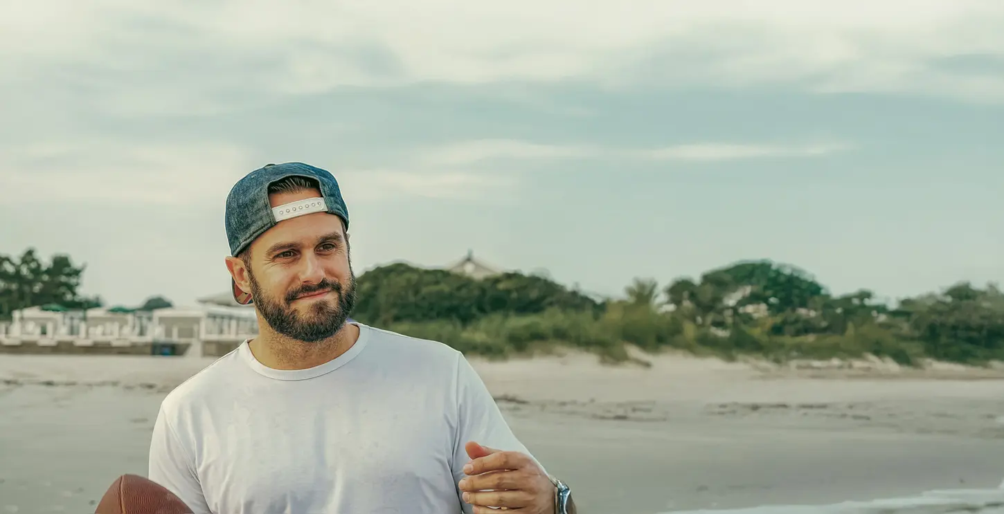 Doug Newton on a beach in Rhode Island at sunset playing with a football