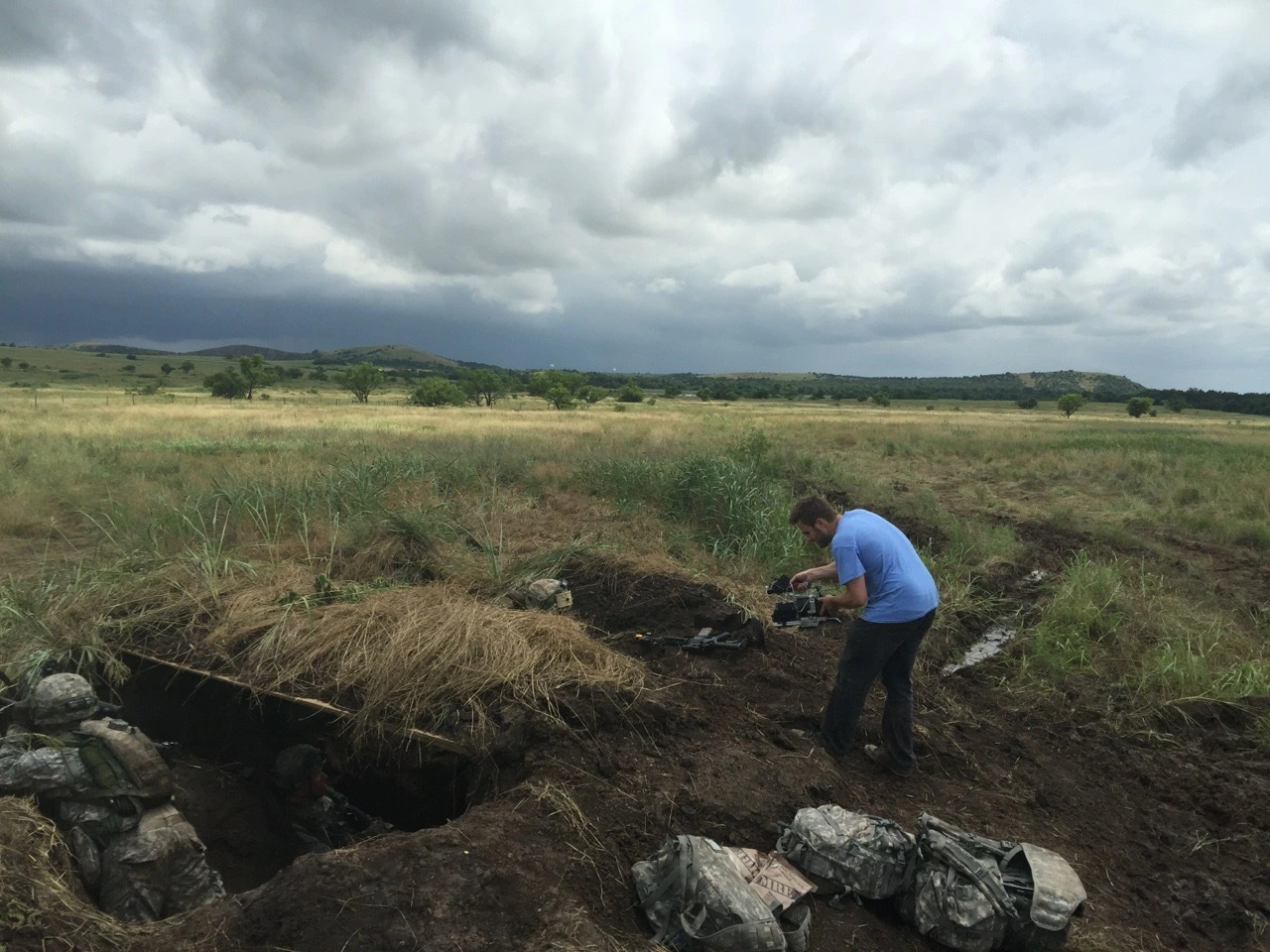 Doug Newton operating a camera during Oklahoma National Guard training in an open field