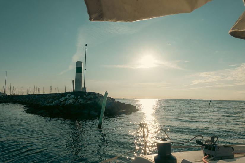 View of the breakwater and channel marker as the sailboat leaves the marina