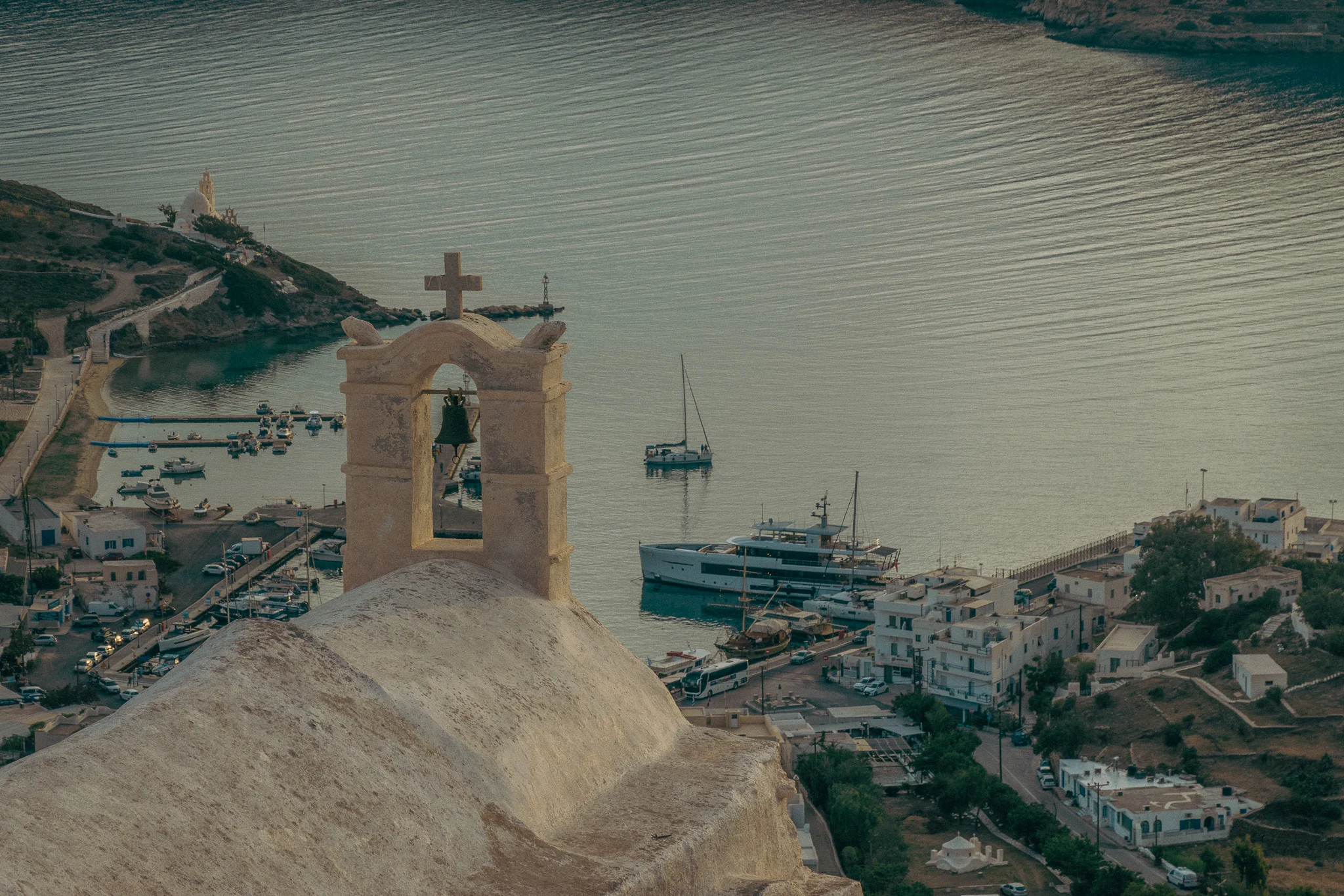A chapel bell overlooking the water and harbor at dusk