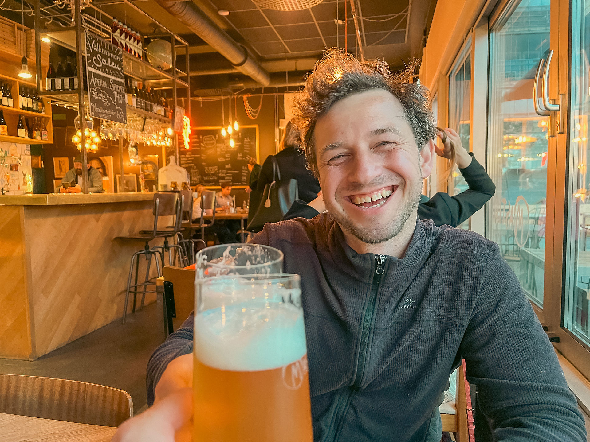 Alex and Doug toasting full beer glasses and smiling in Malmo Sweden