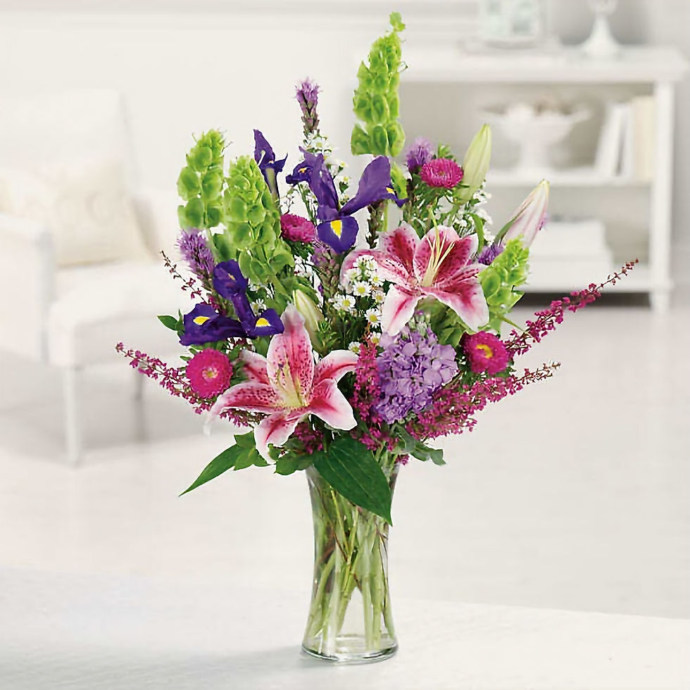 Tall vase arrangement with pink and white starlight lilies, blue irises, bells of Ireland, purple stock