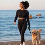 Fit woman walking on beach with dog